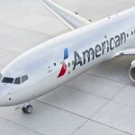 American Airlines jet taxiing on runway amid declining U.S. travel demand, symbolizing airline industry profit warnings and weakened consumer spending.