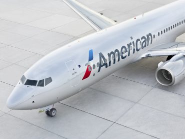 American Airlines jet taxiing on runway amid declining U.S. travel demand, symbolizing airline industry profit warnings and weakened consumer spending.