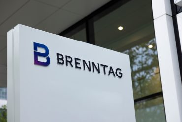 Brenntag chemical logistics facility with delivery trucks and containers, reflecting market downgrade and sector slowdown.