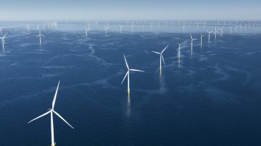 Offshore wind turbines at sea under clear skies, symbolizing Orsted’s renewable energy expansion and stock rally.