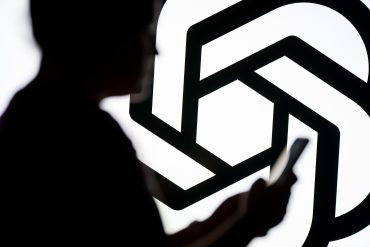 POLAND - 2025/03/07: In this photo illustration, a woman seen looking at a smartphone with a Chat GPT logo displayed in the background. (Photo Illustration by Mateusz Slodkowski/SOPA Images/LightRocket via Getty Images)