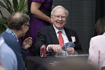 Warren Buffett, chairman of Berkshire Hathaway Inc., center, laughs with Bill Gates, chairman and founder of Microsoft Corp. and a Berkshire Hathaway Inc. director, left, as they play bridge during a shareholder event on the sidelines of the Berkshire Hathaway Inc. annual shareholders meeting in Omaha, Nebraska, U.S., on Sunday, May 3, 2015. More than 40,000 people were expected to attend yesterday's Berkshire Hathaway annual meeting, which marks Warren Buffett's 50th year running the company. Photographer: Daniel Acker/Bloomberg via Getty Images