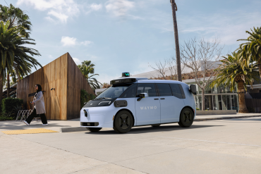 Waymo autonomous vehicle operating in downtown Dallas with skyline in background