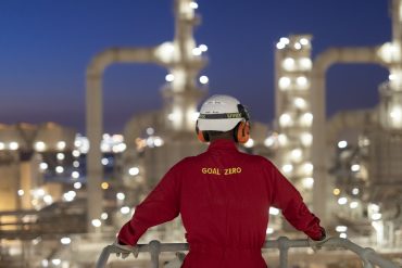 Shell logo at oil refinery under cloudy skies, representing energy sector uncertainty and Q2 production challenges