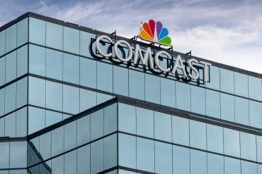 Comcast streaming and mobile revenue surge shown on screen with Q2 financial data overlay and digital devices