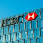 HSBC logo on global headquarters with financial charts reflecting profit drop and China real estate exposure