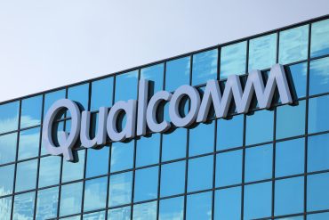 Qualcomm headquarters in San Diego with digital automotive and IoT icons overlayed, symbolizing the company’s diversification strategy
