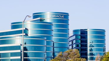 Oracle data center illuminated with AI symbols and charts rising, representing enterprise cloud investment surge amid shifting CIO priorities.