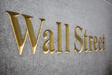 Wall Street gold-letter signage on stone facade symbolizing U.S. market momentum