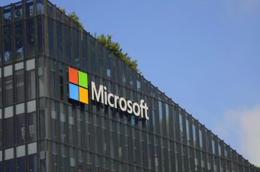 Microsoft office building with AI-themed visual overlay, symbolizing tech layoffs and transition to AI-driven operations.