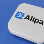 Customer tapping phone at checkout terminal with Alipay logo visible, showcasing contactless NFC payment in a Chinese retail store.