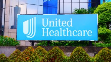 UnitedHealth headquarters with falling stock chart and rising healthcare cost visuals symbolizing forecast downgrade and industry pressure.