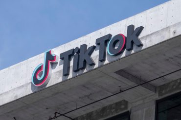 TikTok logo split between American and Chinese flags, symbolizing forced app migration and geopolitical tech tensions.
