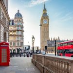 Red telephone box and double-decker bus on Parliament square and Big Ben tower, London, UK