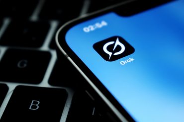 iPhone screen showing Grok app icon — symbol of Elon Musk’s AI competing in top global model rankings with rising influence and controversy.