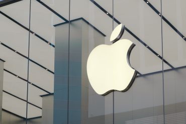 Apple store exterior with customers walking by, reflecting strong iPhone sales in Q3 2025