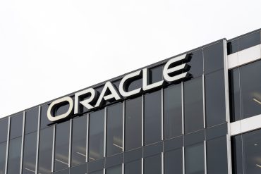 Rows of Oracle-badged GPU servers in a high-density AI cluster. Austin, Texas, USA - March 17, 2022: Closeup of Oracle sign on the building at its headquarters in Austin, Texas, USA. Oracle Corporation is an American multinational computer technology corporation.