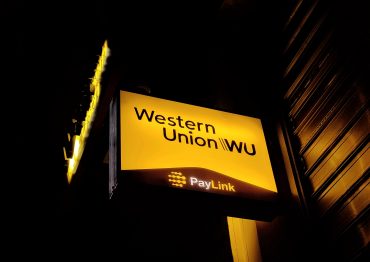 Western Union signage displayed outside a retail money transfer location, symbolizing its $500M Intermex acquisition to expand Hispanic remittance services