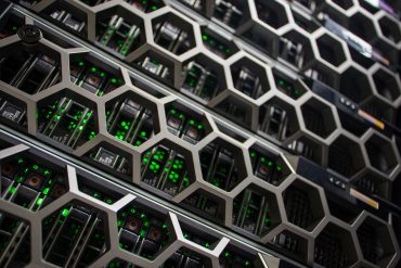 Rows of AI servers with liquid-cooled GPU trays in a new data center.