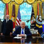 US President Donald Trump and Howard Lutnick, US commerce secretary, left, in the Oval Office of the White House in Washington, DC, US, on Friday, Sept. 19, 2025. Trump is signing a proclamation that would move to extensively overhaul the H-1B visa program, requiring a $100,000 fee for applications in a bid to curb overuse, according to a White House official familiar with the matter. Photographer: Aaron Schwartz/CNP/Bloomberg via Getty Images
