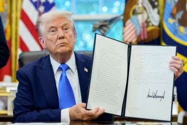 US President Donald Trump holds a signed executive order authorizing the Trump Gold Card in the Oval Office of the White House in Washington, DC, US, on Friday, Sept. 19, 2025. Trump is signing a proclamation that would move to extensively overhaul the H-1B visa program, requiring a $100,000 fee for applications in a bid to curb overuse, according to a White House official familiar with the matter. Photographer: Aaron Schwartz/CNP/Bloomberg via Getty Images