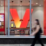 Exterior of a Verizon retail store in New York City featuring the company’s red logo and glass storefront.