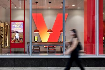 Exterior of a Verizon retail store in New York City featuring the company’s red logo and glass storefront.