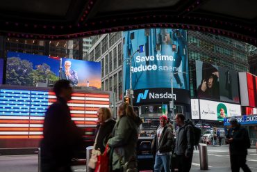 New York Nasdaq MarketSite building with digital stock tickers highlighting Big Tech dominance in the S&P 500, and Magnificent Seven Q3 earnings
