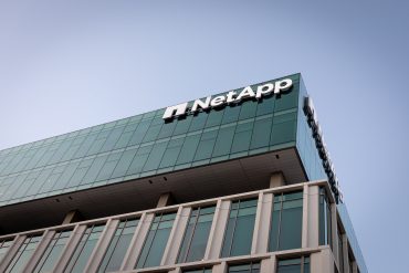 NetApp headquarters building with company logo displayed on modern glass facade in California, as hybrid cloud grows