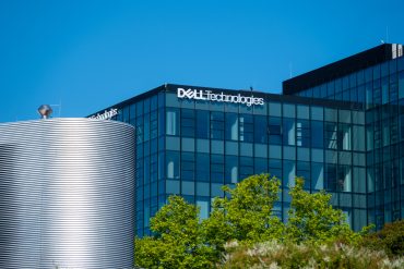 Exterior view of Dell Technologies headquarters building with corporate logo displayed prominently on a modern glass facade.