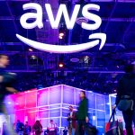 AWS re:Invent conference hall featuring the AWS logo and blurred attendees walking through the venue during the announcement of new AI agent marketplace features.