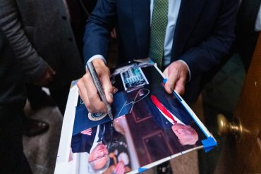 Nvidia CEO Jensen Huang signing a photo with President Donald Trump after their Capitol Hill meeting in Washington on December 3