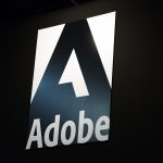 Adobe logo illuminated at dusk, symbolizing the company’s shift toward AI-first creative and experience platforms.