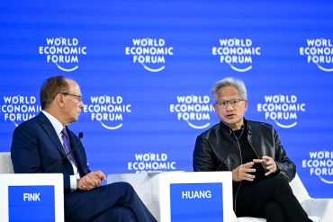 Larry Fink with NVIDIA CEO Jensen Huang during a Davos session focused on AI infrastructure, compute power, and semiconductor leadership.