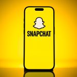 Snap strengthens margins and subscription revenue while user growth declines, as Snapchat app logo appears on an iPhone screen.