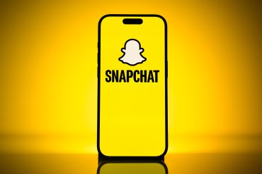 Snap strengthens margins and subscription revenue while user growth declines, as Snapchat app logo appears on an iPhone screen.