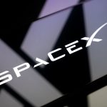 SpaceX logo displayed on a reflective surface, representing the aerospace and satellite communications company behind Starlink, Falcon 9, and Starship.