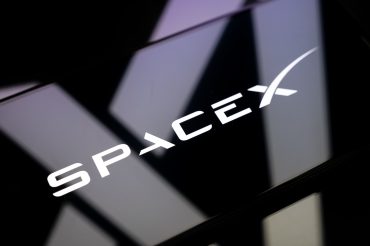 SpaceX logo displayed on a reflective surface, representing the aerospace and satellite communications company behind Starlink, Falcon 9, and Starship.