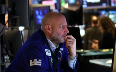 Trader on the New York Stock Exchange floor as U.S. payrolls fall by 92,000, signaling labor market weakness.