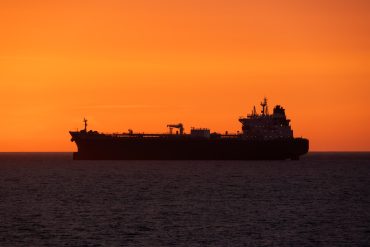 Oil tanker navigating the Strait of Hormuz as Brent crude prices surge above $90 amid escalating U.S.–Iran tensions.