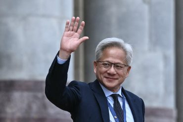 Nvidia founder and CEO Jensen Huang waves during the Beijing summit as semiconductor negotiations, Nvidia China export controls, and AI chip trade tensions remain central to U.S.-China discussions.