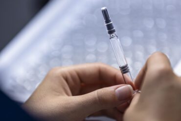 Scientist holding a laboratory test tube during pharmaceutical research at Novo Nordisk, illustrating Ziltivekimab, ZEUS trial, IL-6 inhibitor research, cardiovascular inflammation therapy, heart disease treatment and clinical drug development.