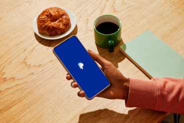 Hand holding a smartphone displaying the PayPal app as Stripe and Advent proposed a PayPal acquisition, highlighting digital payments, fintech, stablecoin payments, and the payments industry.