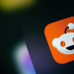 Reddit logo displayed on a smartphone screen, illustrating Reddit Q2 earnings, revenue growth, advertising revenue, Google traffic concerns, Reddit stock performance and quarterly financial results.