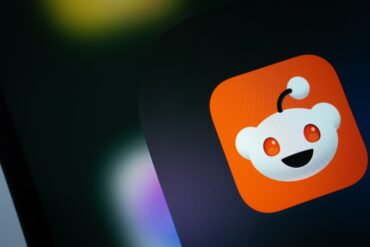 Reddit logo displayed on a smartphone screen, illustrating Reddit Q2 earnings, revenue growth, advertising revenue, Google traffic concerns, Reddit stock performance and quarterly financial results.