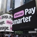 Screens displaying Klarna logos during the company's IPO and stock market debut, illustrating Klarna's transition from a private fintech company to a publicly traded business. The image accompanies coverage of Klarna's earnings, profitability, revised full-year guidance, executive departures, and U.S. banking expansion.