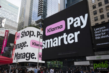 Screens displaying Klarna logos during the company's IPO and stock market debut, illustrating Klarna's transition from a private fintech company to a publicly traded business. The image accompanies coverage of Klarna's earnings, profitability, revised full-year guidance, executive departures, and U.S. banking expansion.