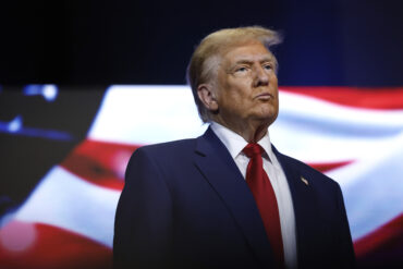 President Donald Trump responding to Dario Amodei's AI slowdown call, dismissing frontier AI safety concerns as a hoax amid debate over AI regulation and Nvidia stock