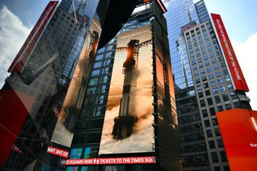 SpaceX displayed on the Nasdaq MarketSite during its IPO, representing SpaceX Q3 earnings, $4.4 billion profit, AI revenue growth, Starlink and SpaceX stock