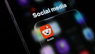 Reddit app icon displayed on a smartphone, representing Reddit Q3 earnings, record profit, U.S. user decline, advertising growth and pressure from Google AI search traffic